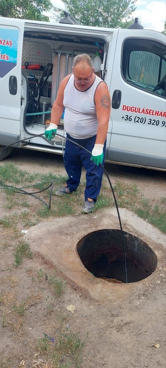 Akna tisztítása csőspirállal a duguláselhárító autó mellett